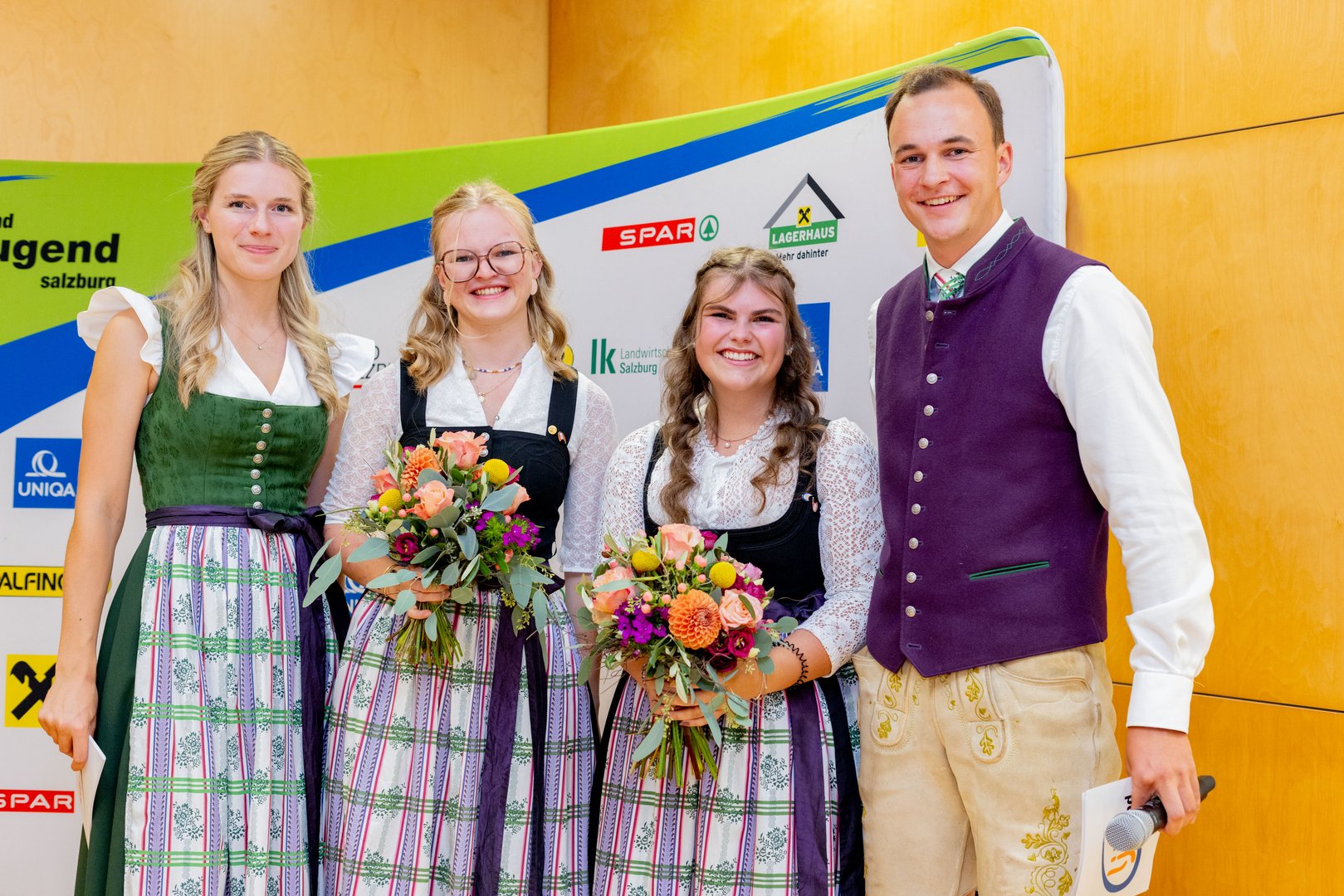 Jugendlandwirtschaft Salzburg: Zwei junge Frauen mit Blumensträußen und ein Mann in Tracht