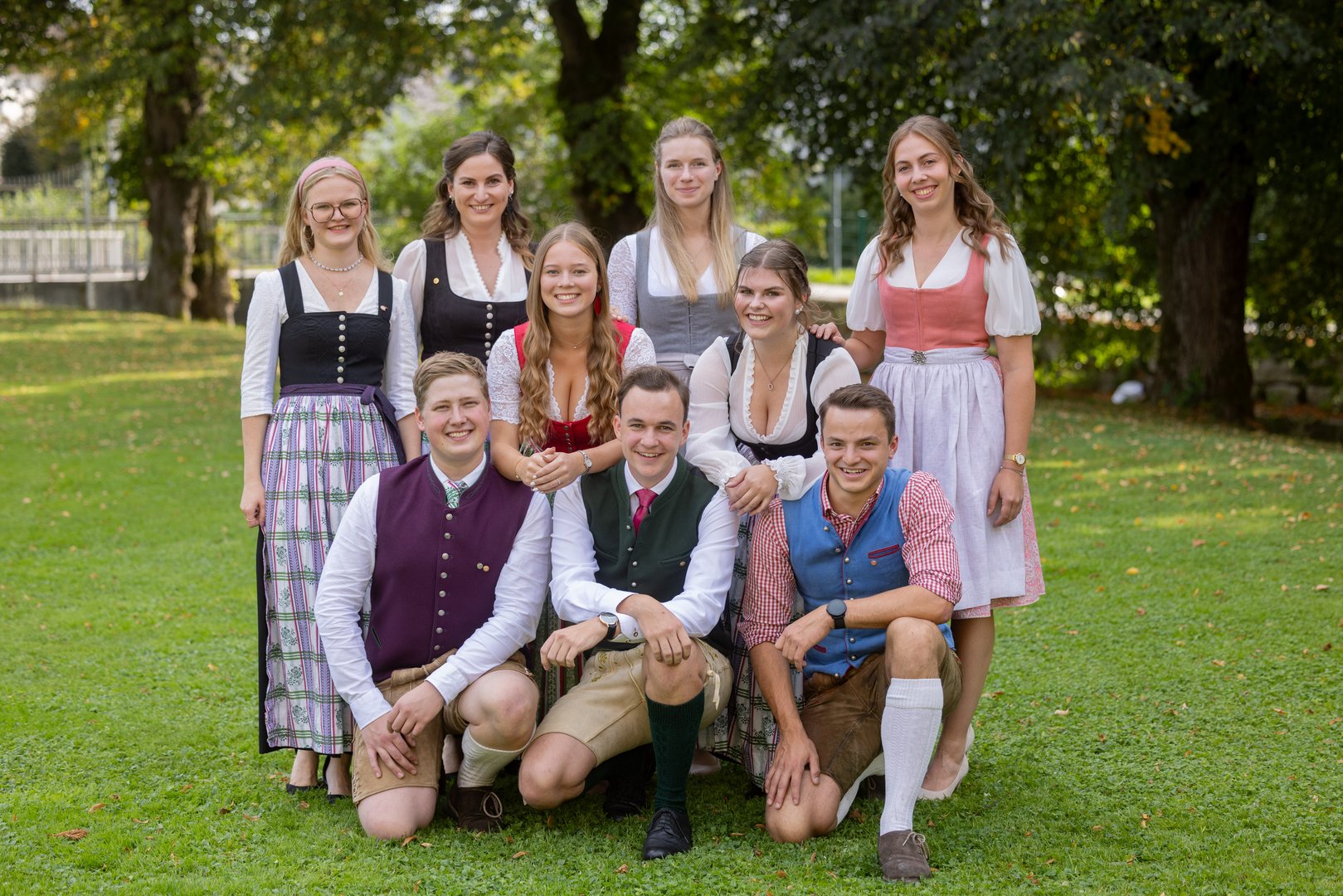 Trachtengruppe mit acht jungen Leuten in traditioneller Kleidung im Freien